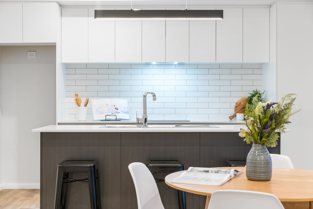 A Kitchen With a Table and Chairs and a Vase of Flowers on the Counter — Stone Effects In Forest Glen, QLD