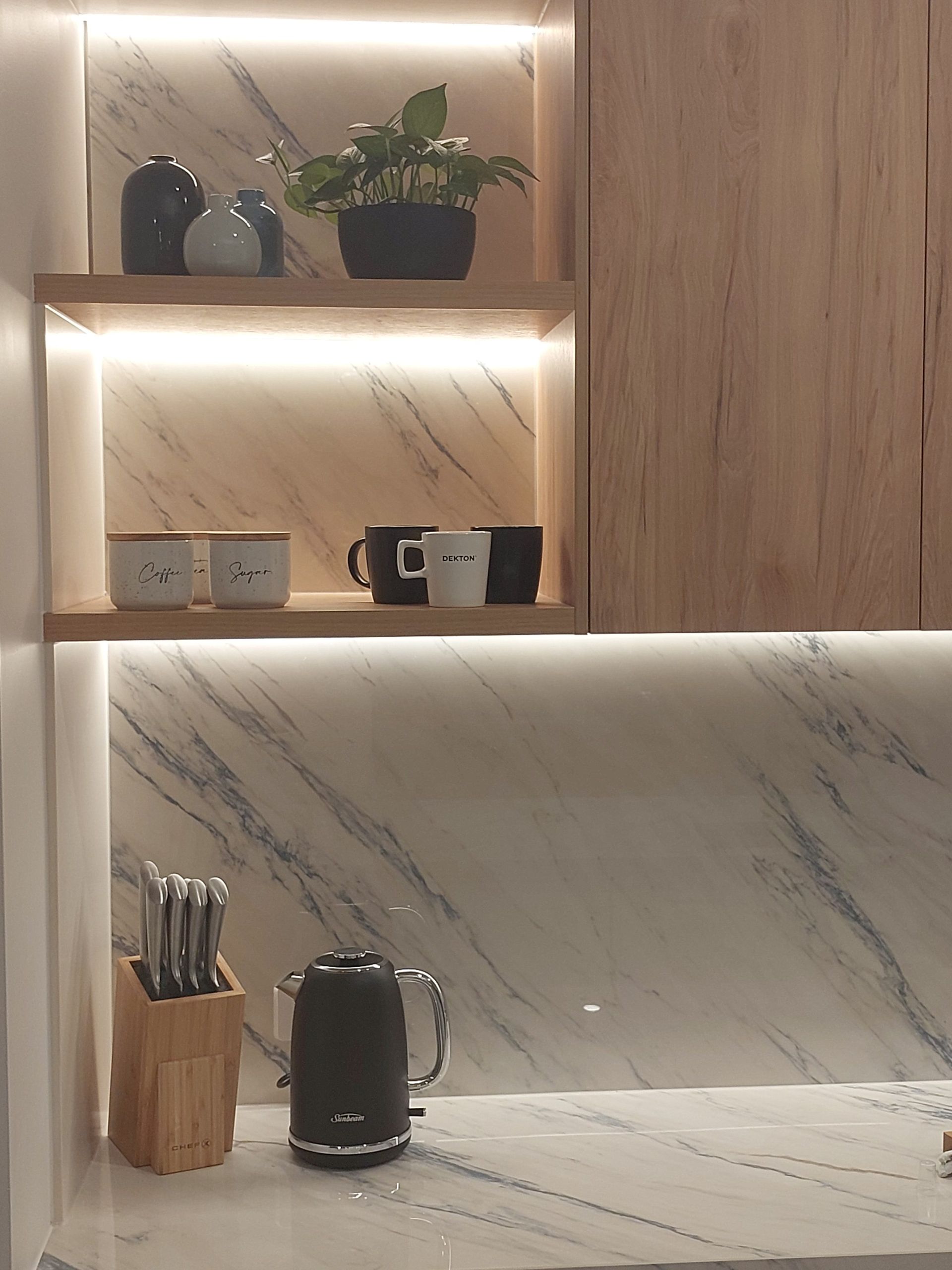 A Kitchen Counter With a Kettle and a Cutting Board on It — Stone Effects In Forest Glen, QLD