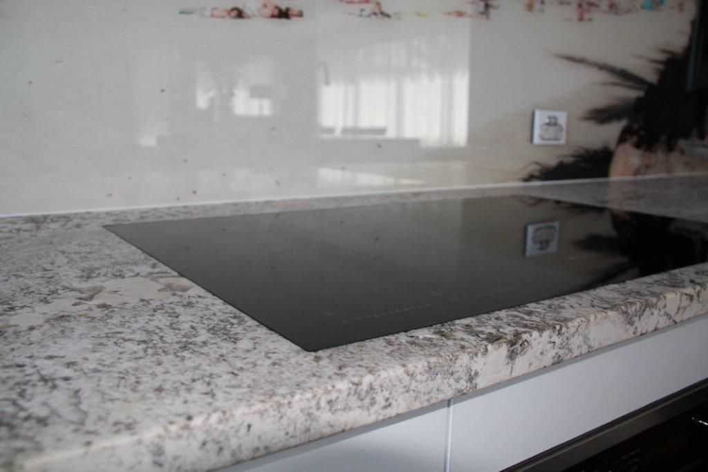 A Stove Top Oven is Sitting on Top of a Granite Counter Top in a Kitchen — Stone Effects In Forest Glen, QLD