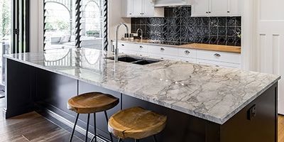 A Kitchen With Marble Counter Tops and Wooden Stools — Stone Effects In Forest Glen, QLD