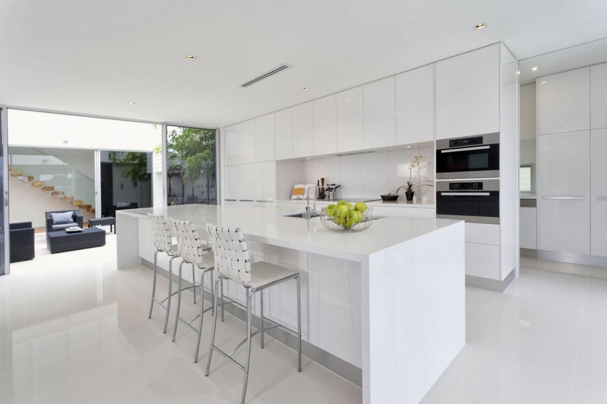A Kitchen With White Cabinets and Stools and a Large Island — Stone Effects In Forest Glen, QLD