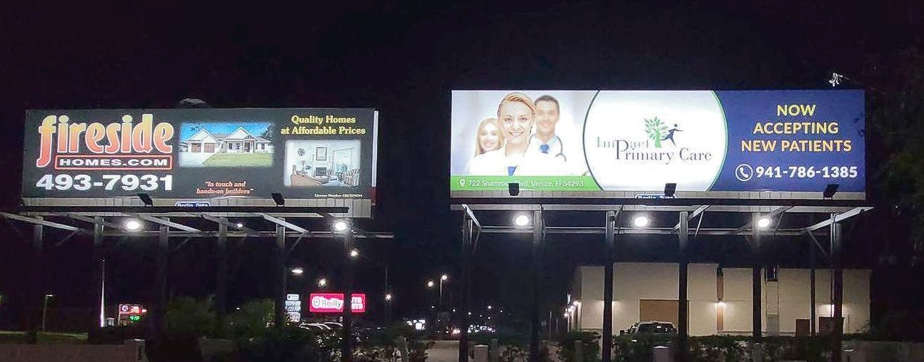 Two billboards are lit up at night and one says fireside