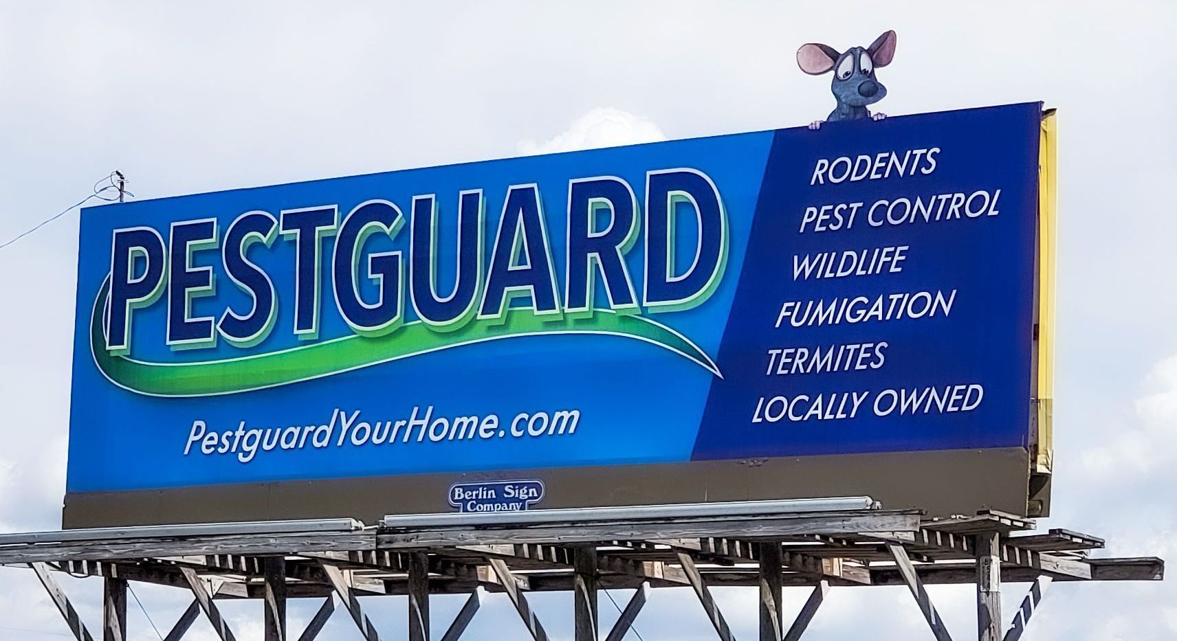 A billboard for pestguard with a mouse on top