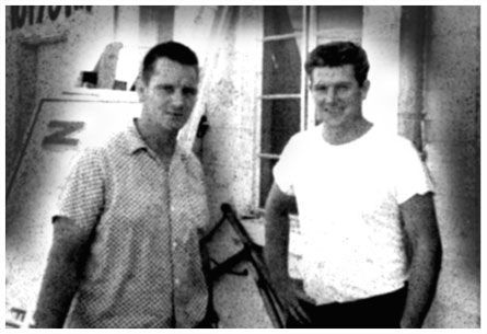 A black and white photo of two men standing next to each other