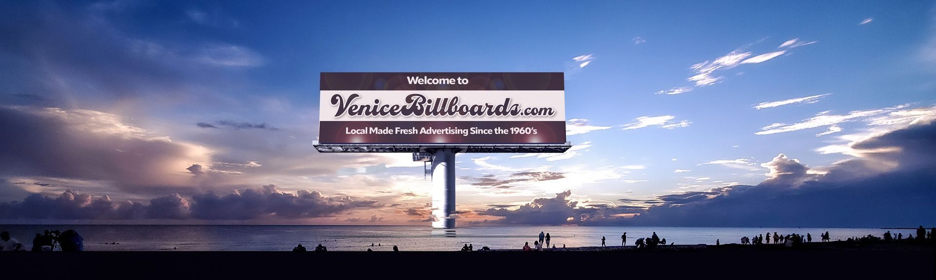 A large billboard is sitting in front of a body of water.