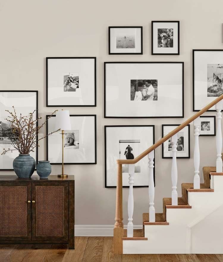 A staircase with a lot of pictures on the wall above it.