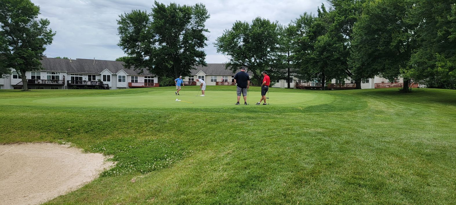 A group of people are walking on a golf course.