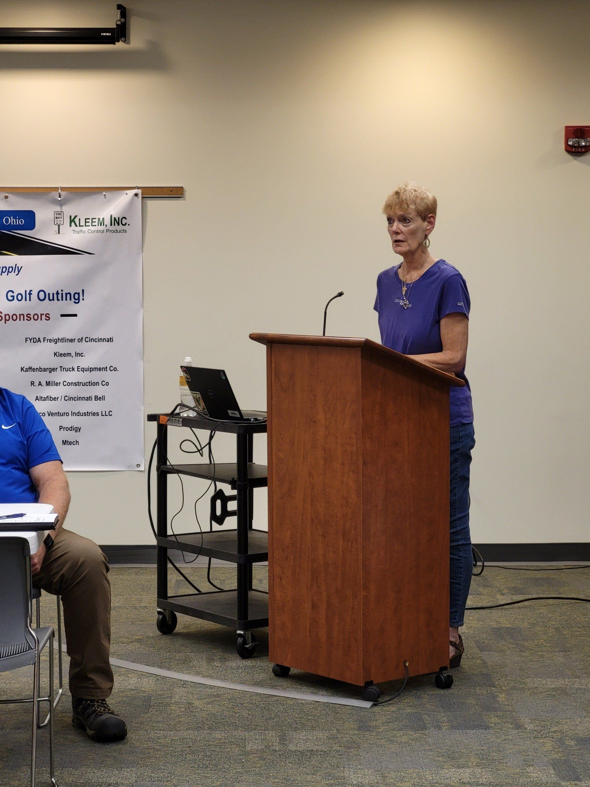 A woman is standing at a podium giving a presentation