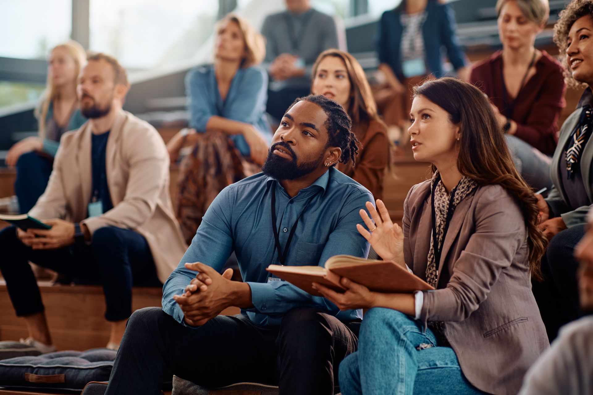 A group of people are sitting in a lecture hall watching a presentation.
