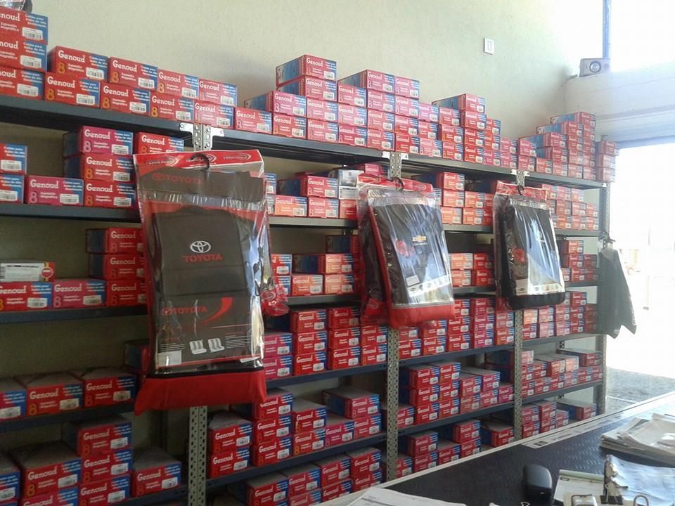 Correa de distribución y piezas del motor dispuestas sobre un banco de trabajo junto a una caja en un taller.