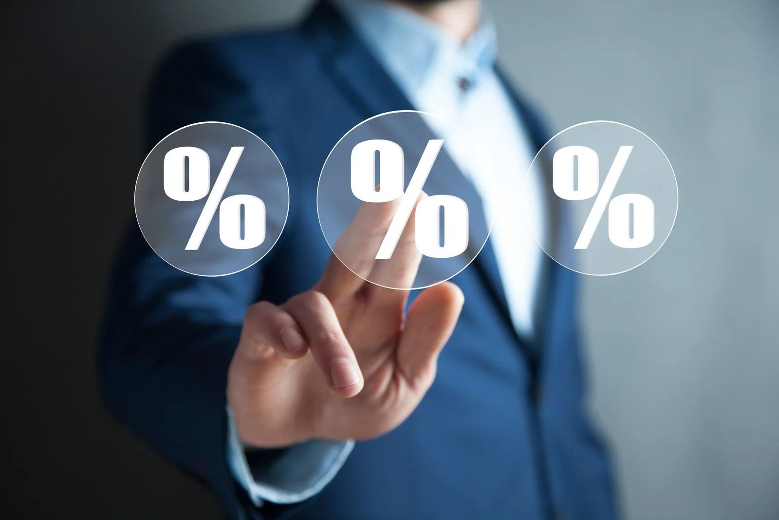 Person in suit touching three percent symbol icons.