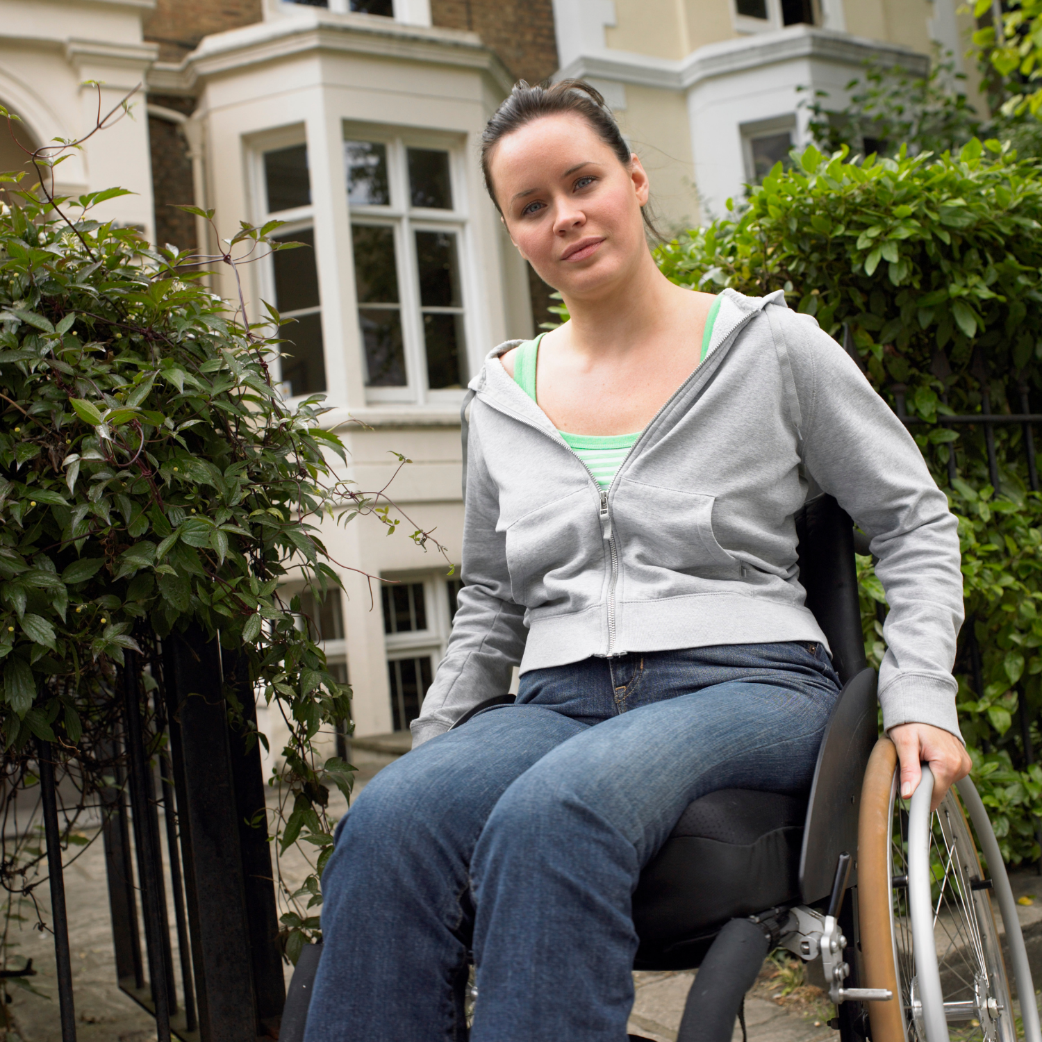a woman in a wheelchair is sitting in front of a building