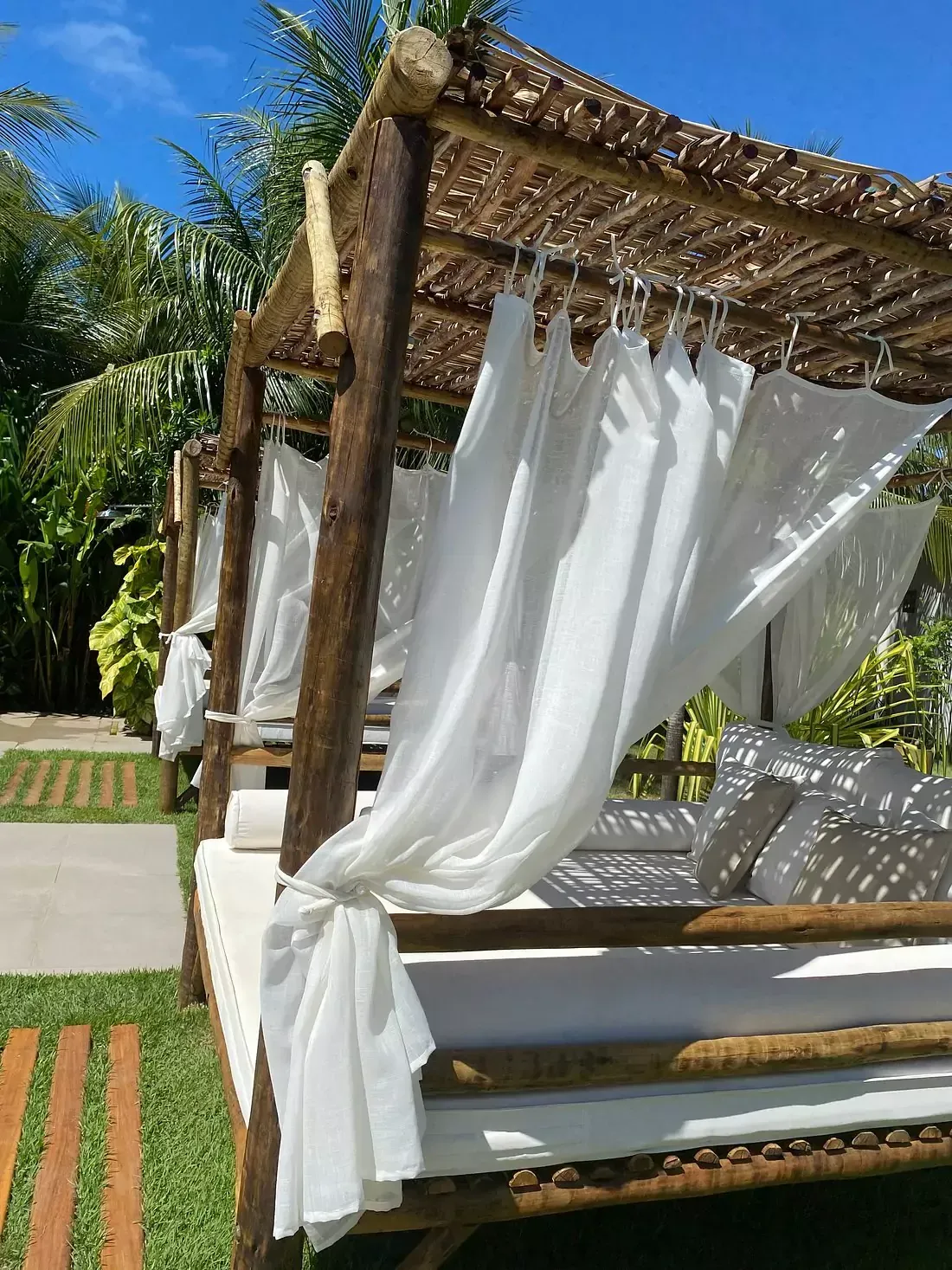 Um sanduíche está em um prato branco sobre uma mesa de madeira.-pousada ocacocar