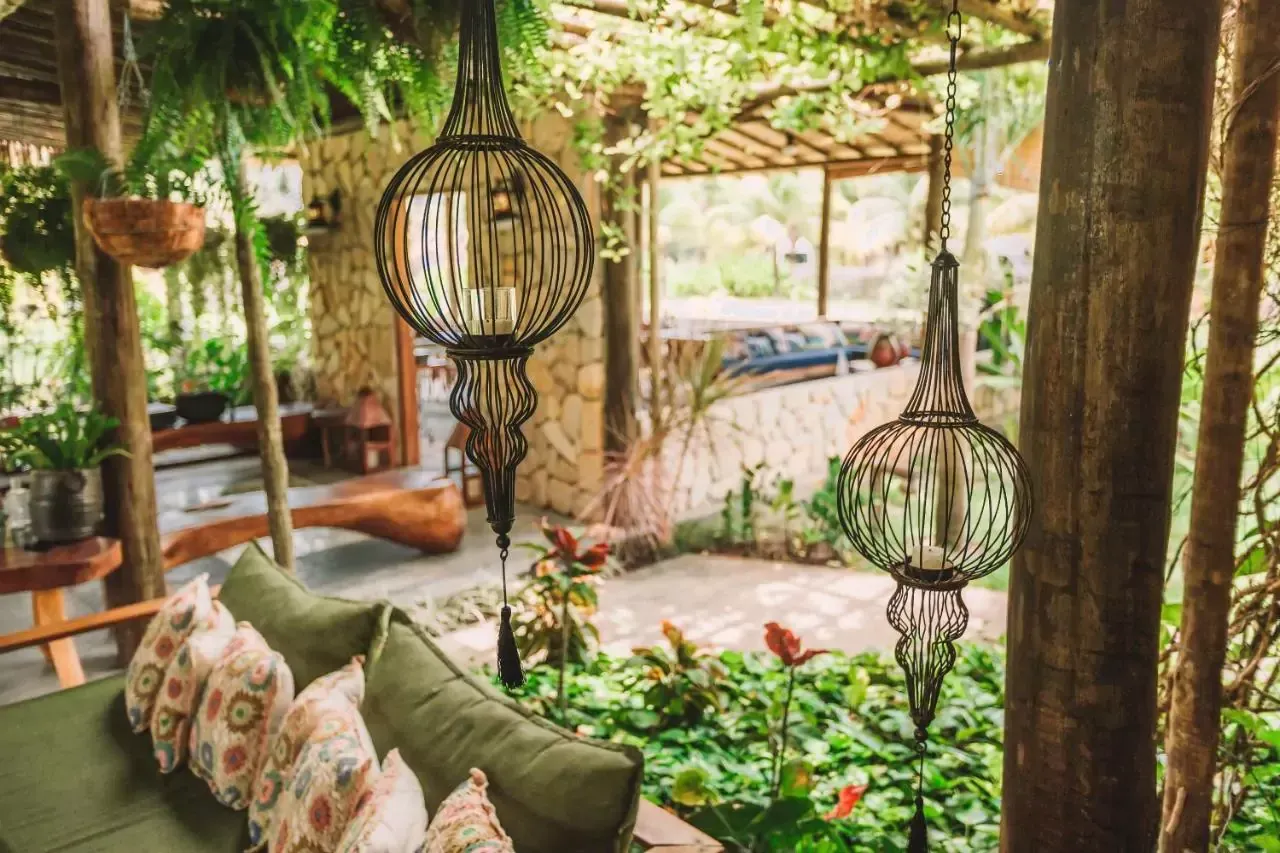 Há muitas lanternas penduradas nas árvores do jardim. pousada ocacocar