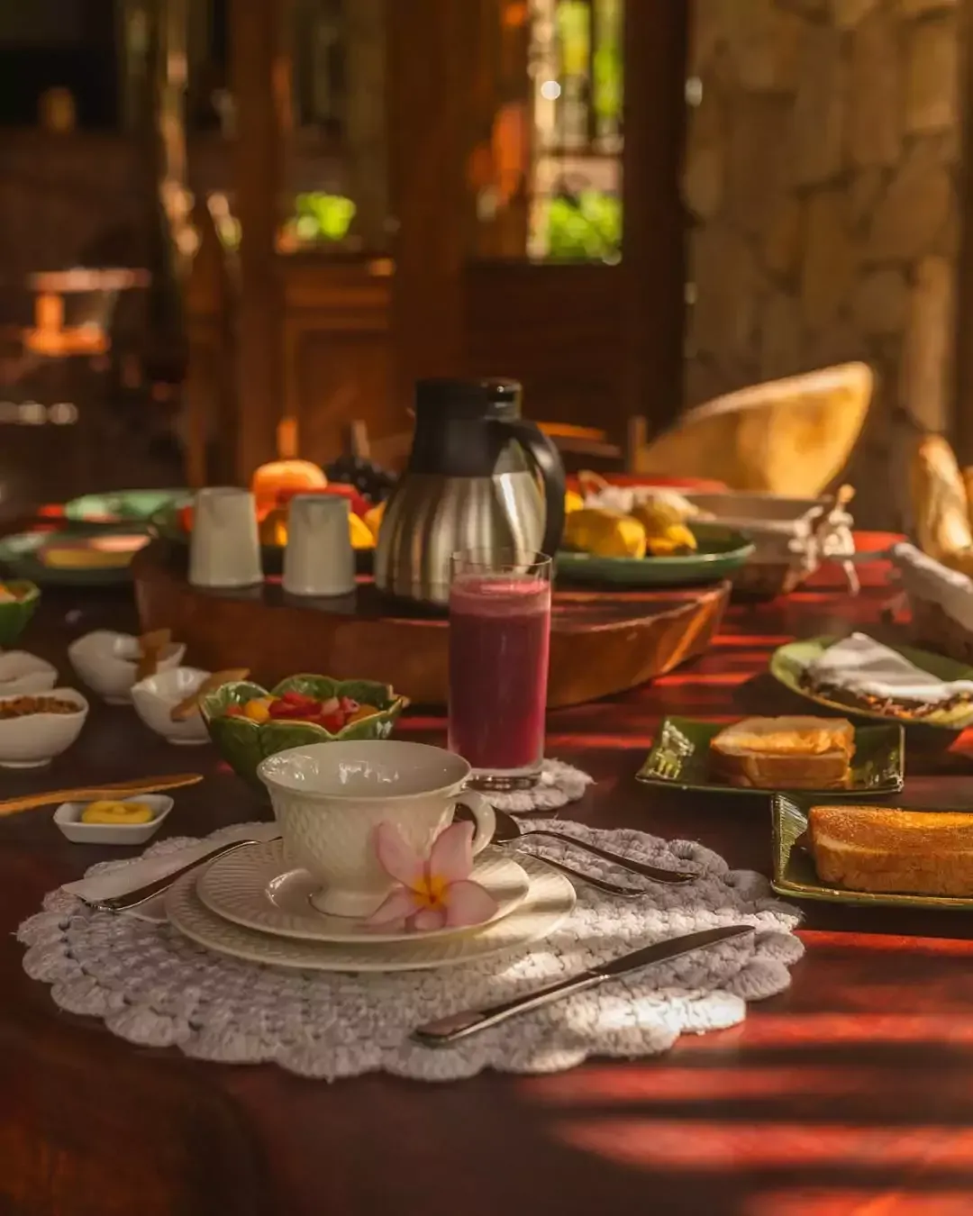 Uma mesa coberta com pratos de comida e bebidas. pousada-ocacocar