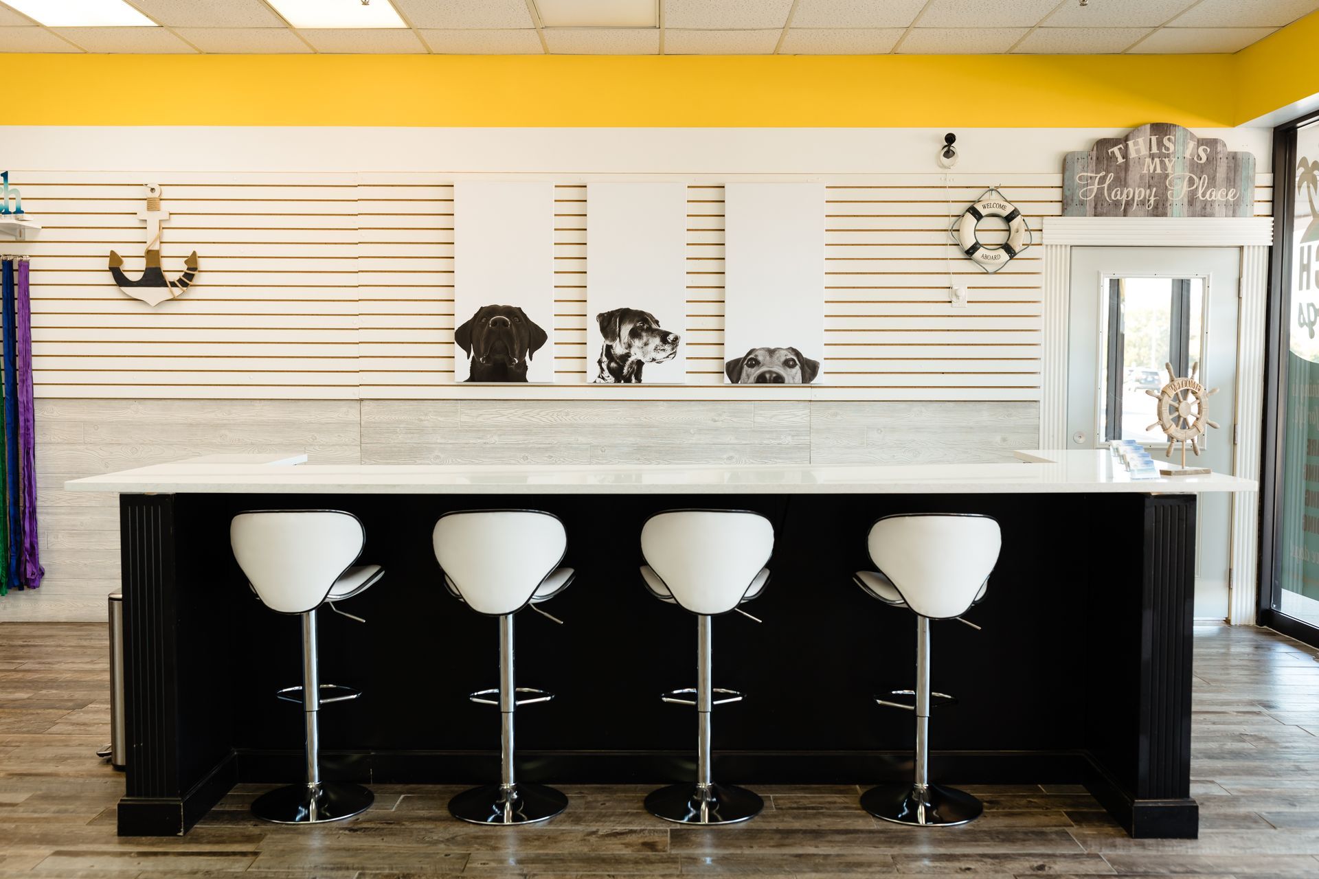 A row of white bar stools in front of a counter in a store