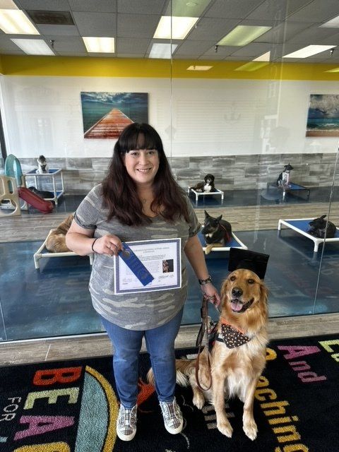 A woman standing next to a dog wearing a graduation cap