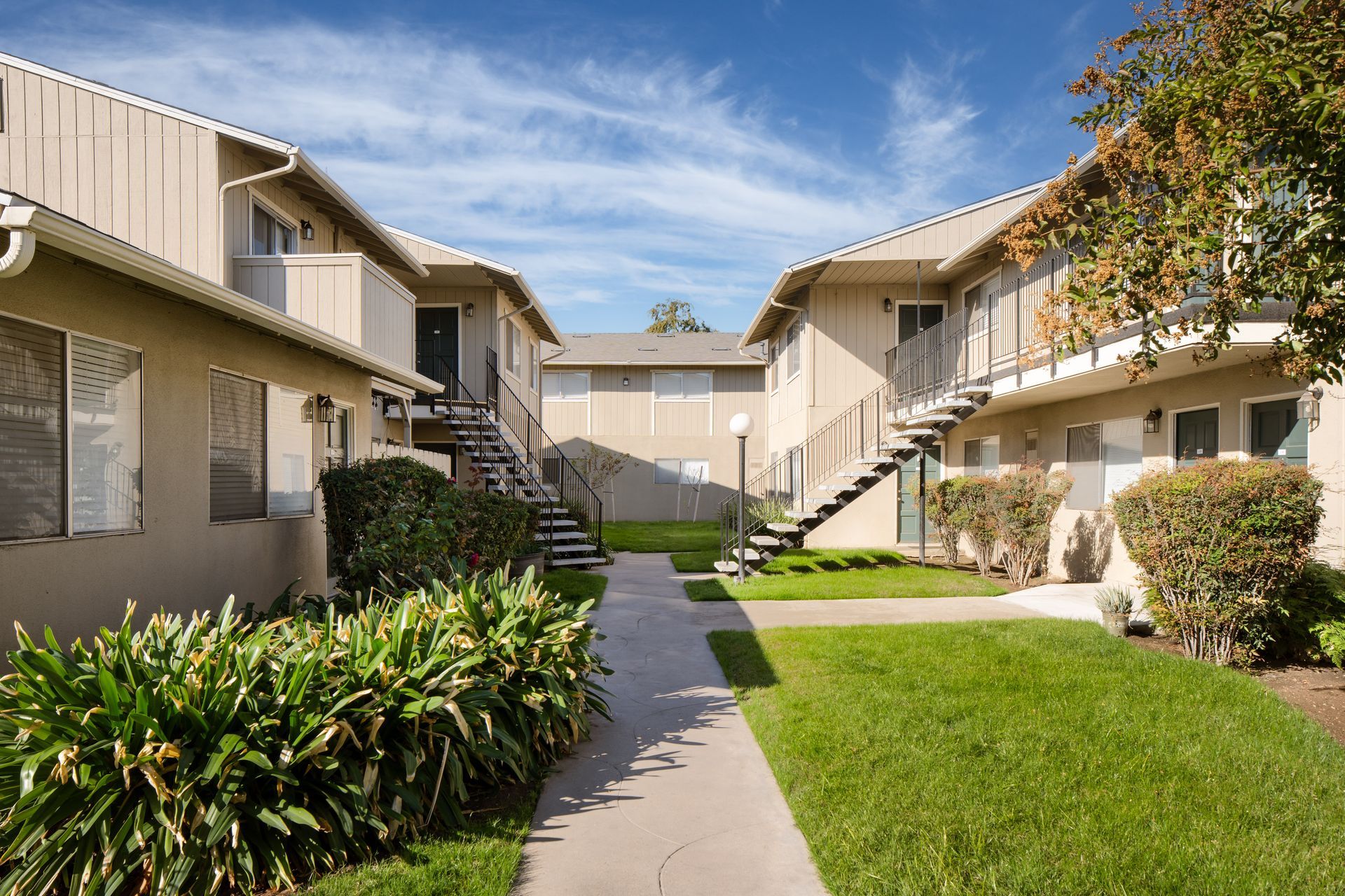 Apartment buildings with staircases and walkways, on a sunny day with blue sky.