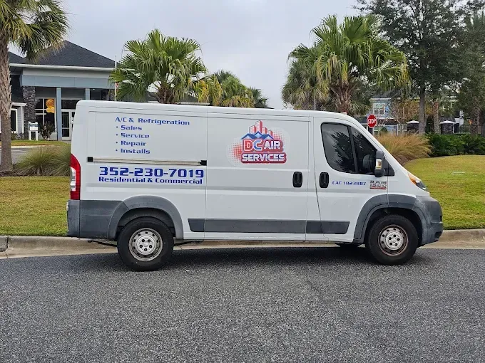 White work van parked on a street;