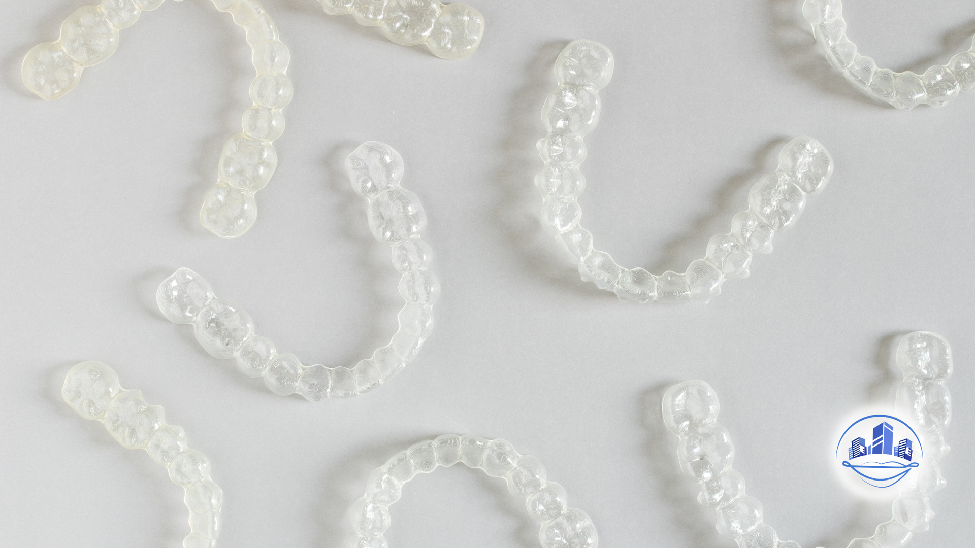 Person holding clear aligner, smiling, preparing to put it in mouth.