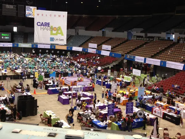 A large group of people are gathered in a large stadium with a sign that says welcome