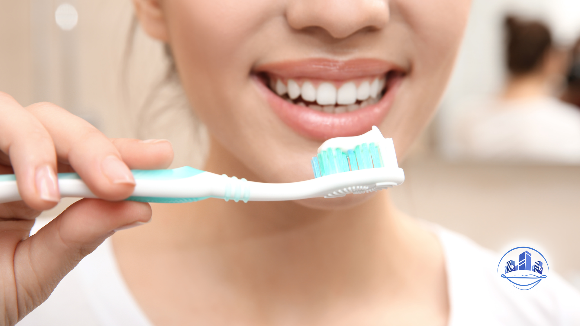 Person holding toothbrush with toothpaste, smiling. Close up, bathroom setting.
