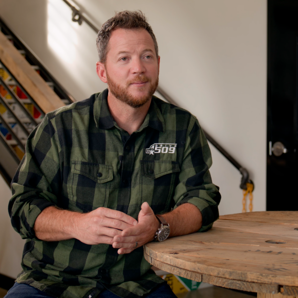 A CDL Instructor smiling, wearing a green plaid shirt.