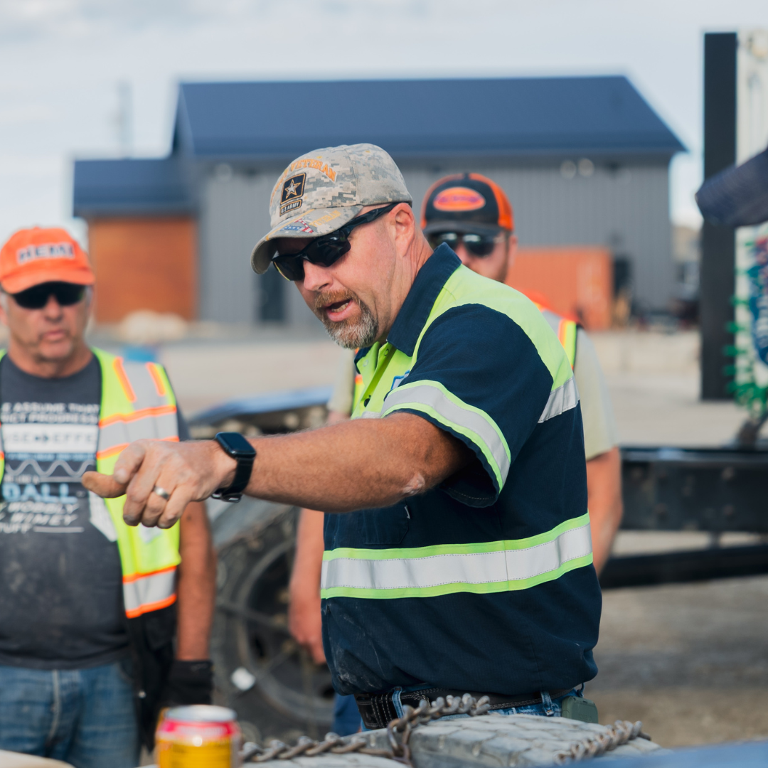 CDL instructor working with cdl student in a trucking yard representing customer feedback and support.
