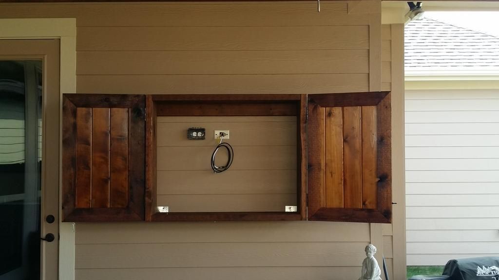 A wooden cabinet on the side of a house