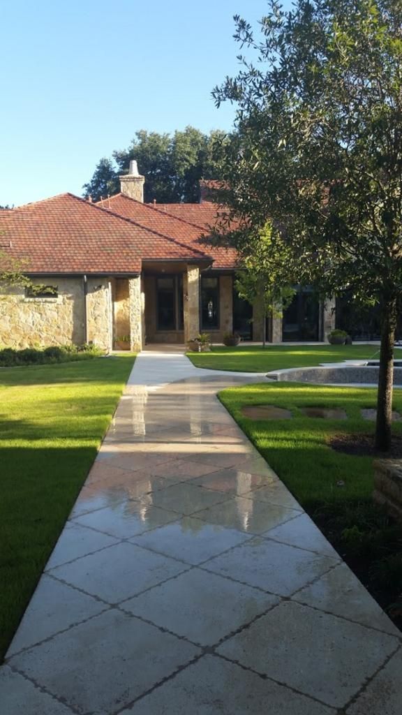 A walkway leading to a house with a red tile roof