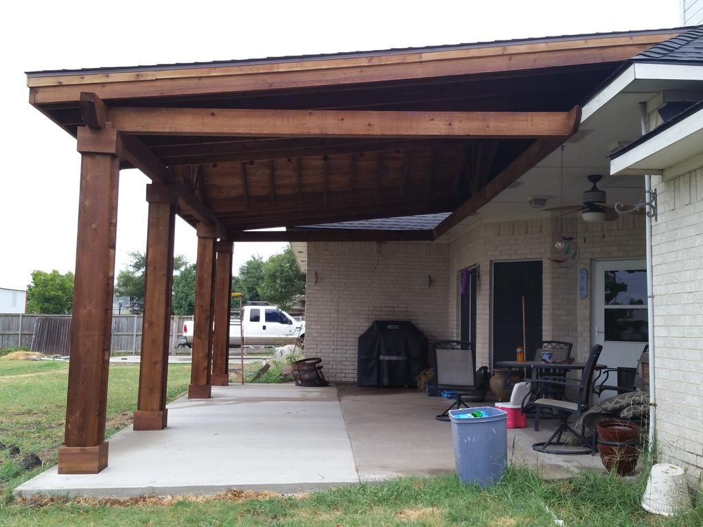 A patio with a wooden roof and a ceiling fan