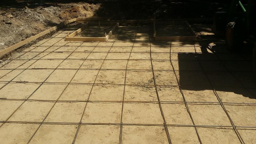 A concrete floor with a grid pattern is being built