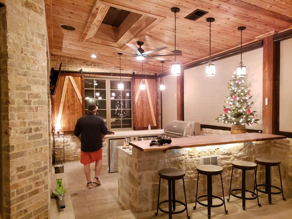 A man is standing in a kitchen with a christmas tree in the background.