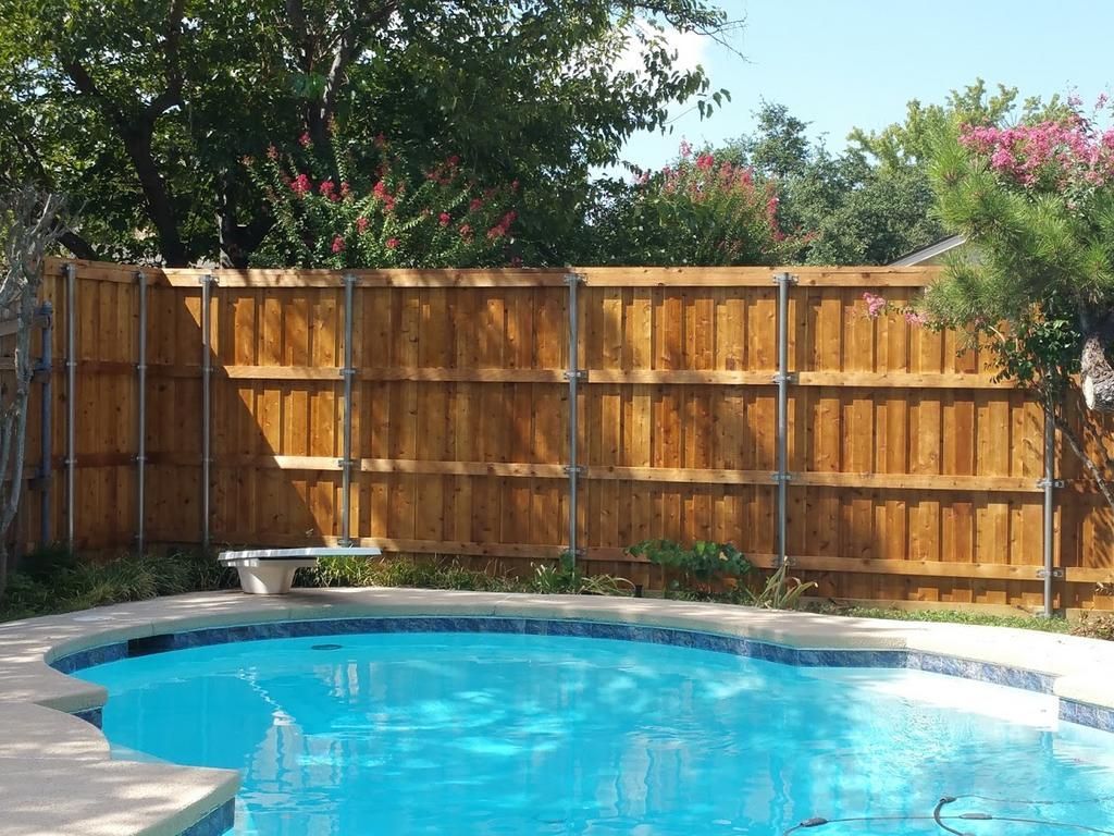 a large swimming pool with a wooden fence surrounding it