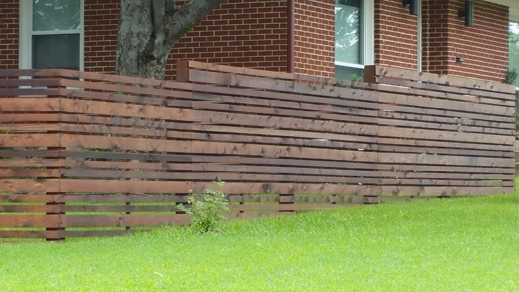 A brick house with a wooden fence in front of it