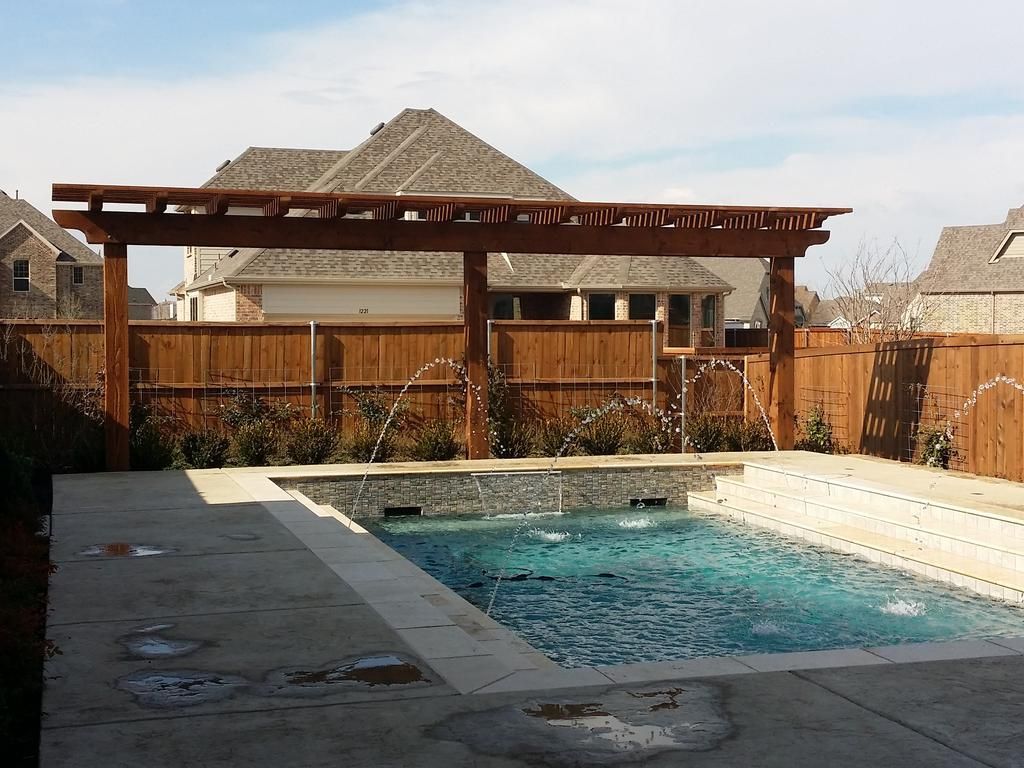 A large swimming pool with a wooden pergola over it