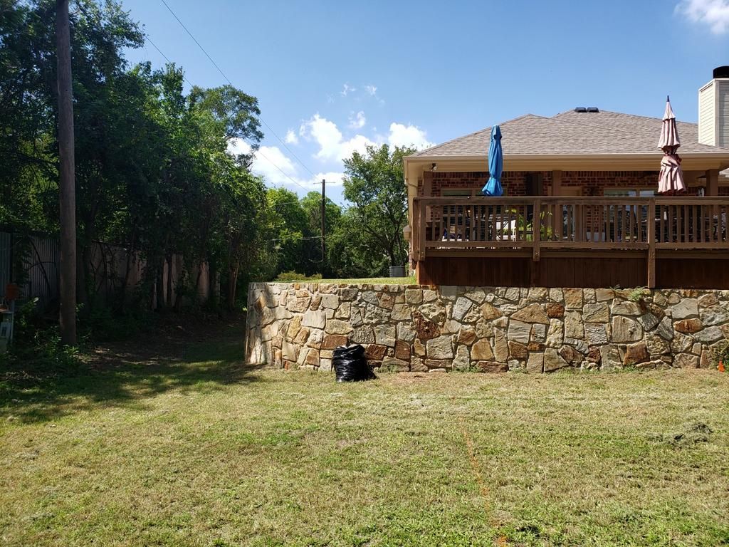 A large house with a stone wall in front of it