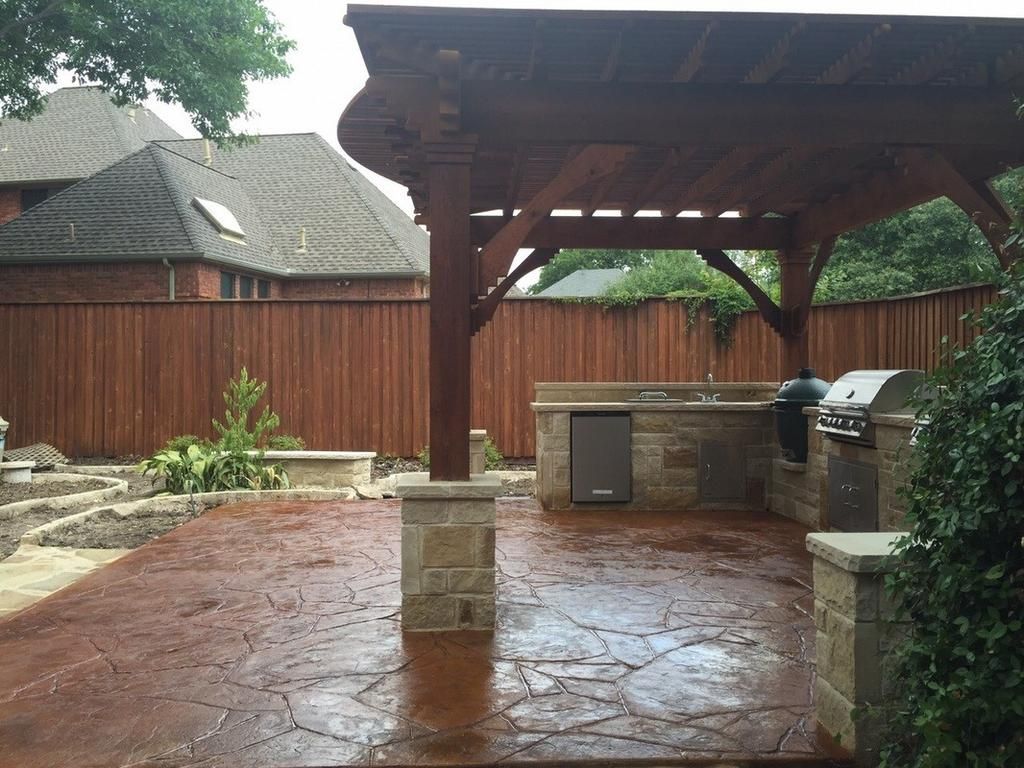 A patio with a grill under a wooden pergola