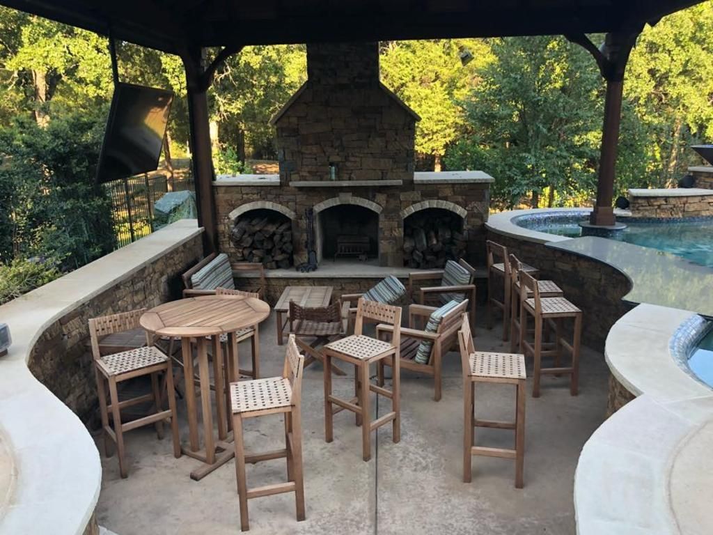 A patio area with tables and chairs and a fireplace.