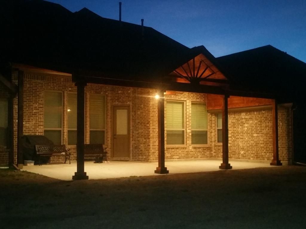 a brick house with a porch that is lit up at night