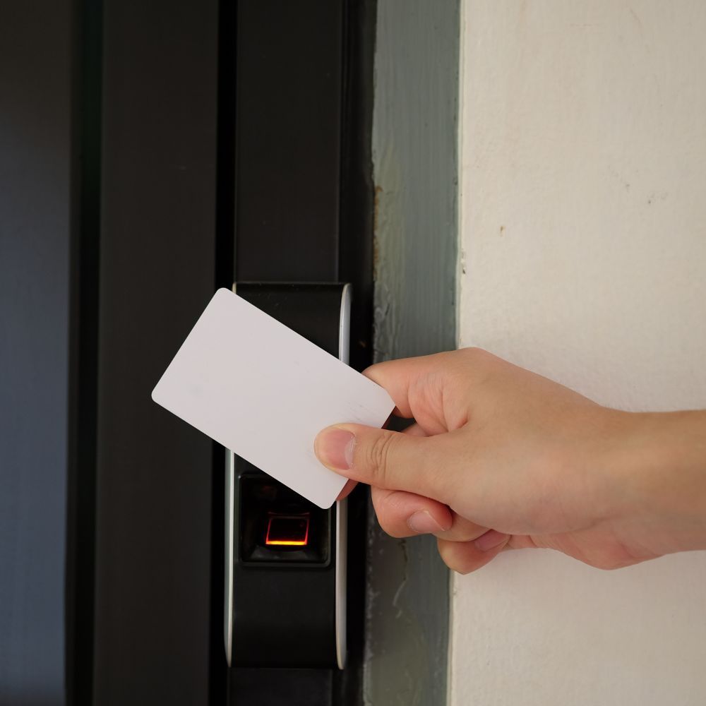 A person is inserting a card into a door lock.