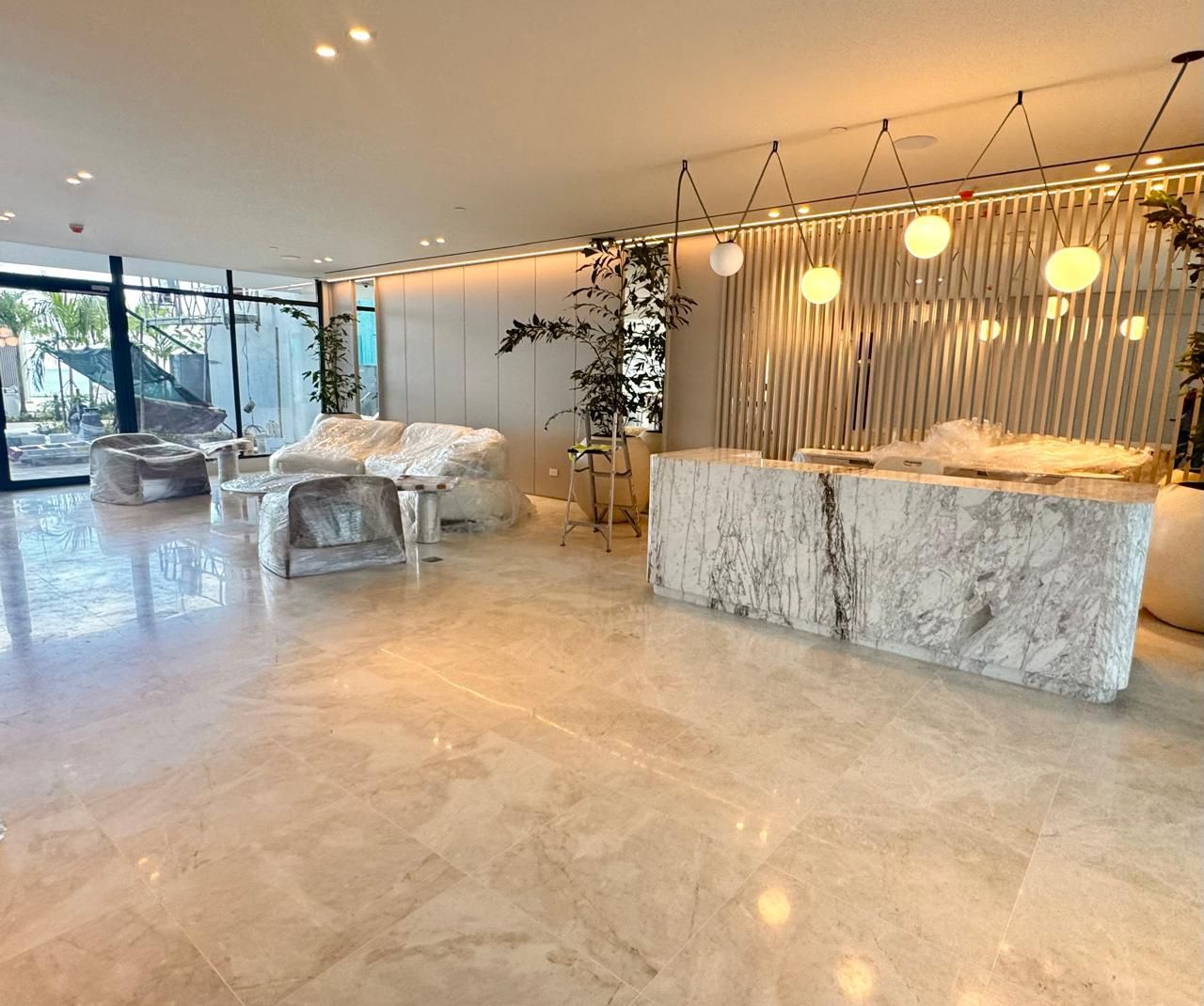 Handyman with tool belt, standing near an open doorway to a kitchen.