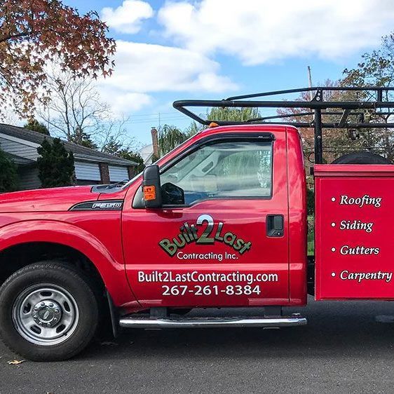 a red truck with built2last contracting written on the side