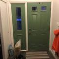 a green door is sitting in a hallway next to a window .