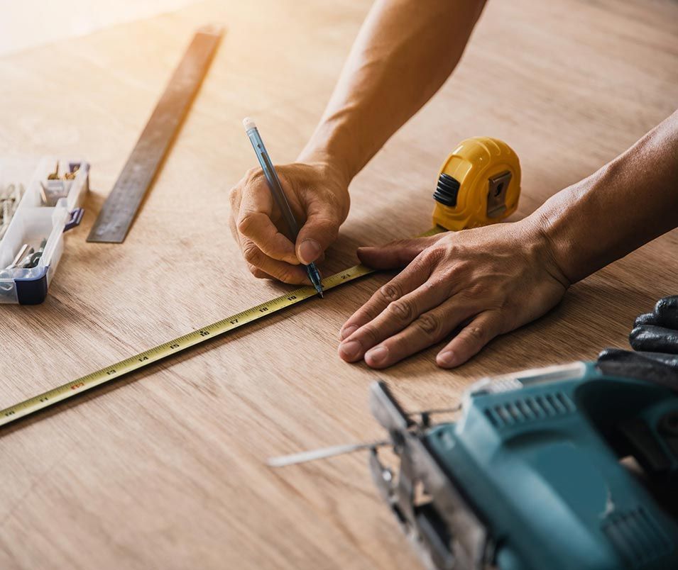 a man is measuring a piece of wood with a tape measure .