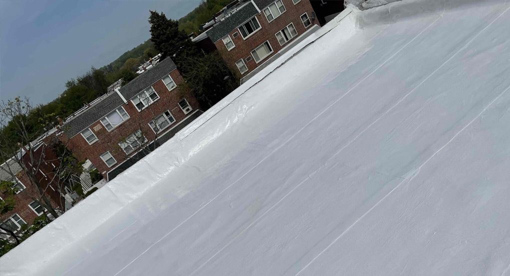 a snow-covered brand new roof with a brick building in the background .
