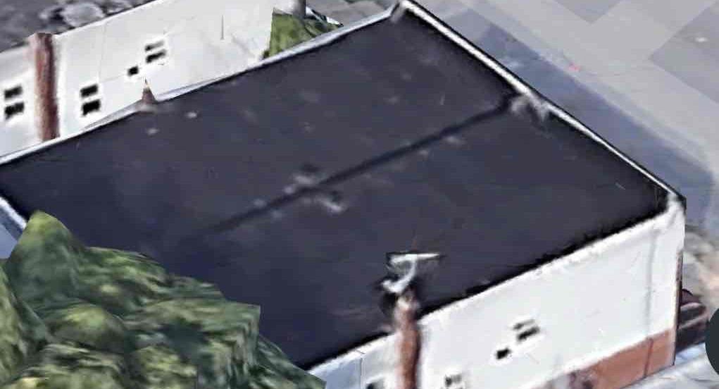 an aerial view of a building with a black roof .