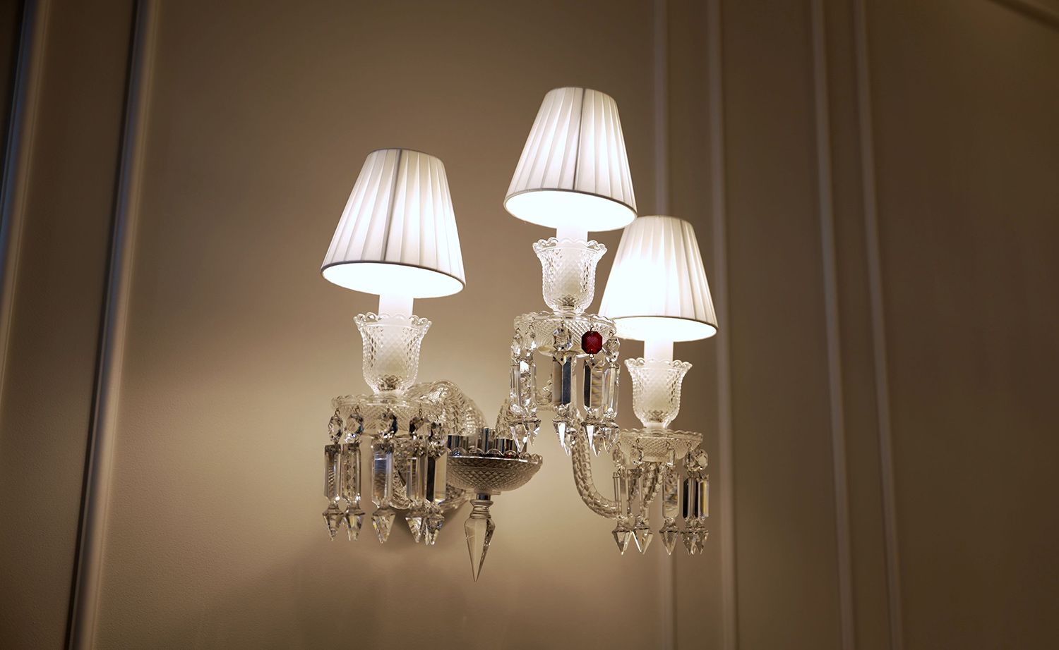 Crystal wall sconce with three white lampshades