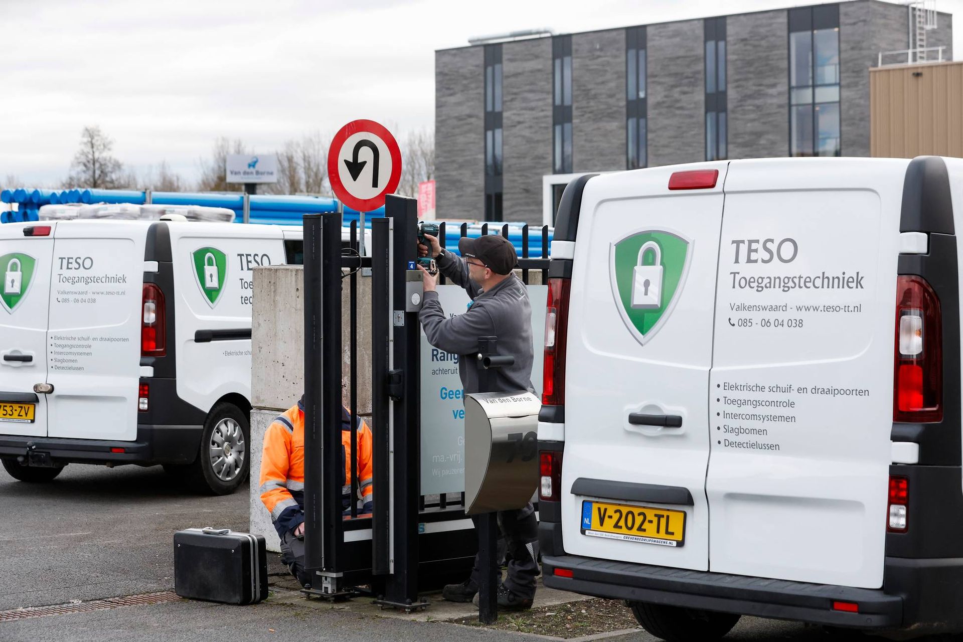 Een man werkt aan een poort voor een teso-busje.