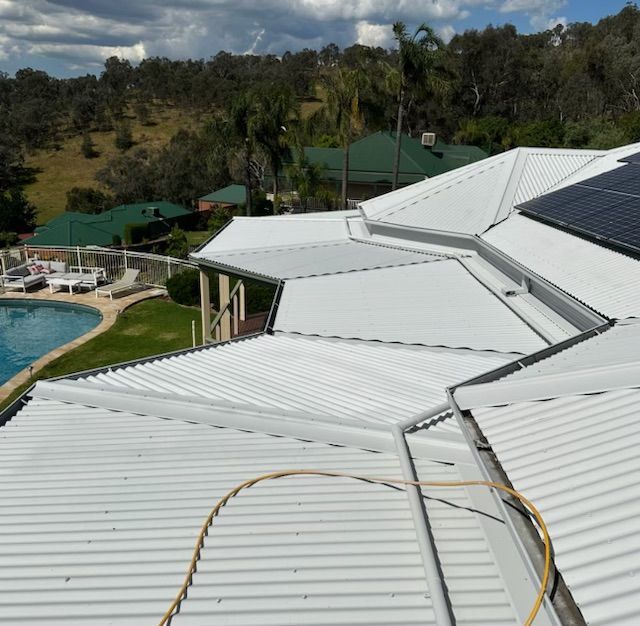 A White Roof With Solar Panels and a Pool in the Background — Skyline Painting In Lavington, NSW